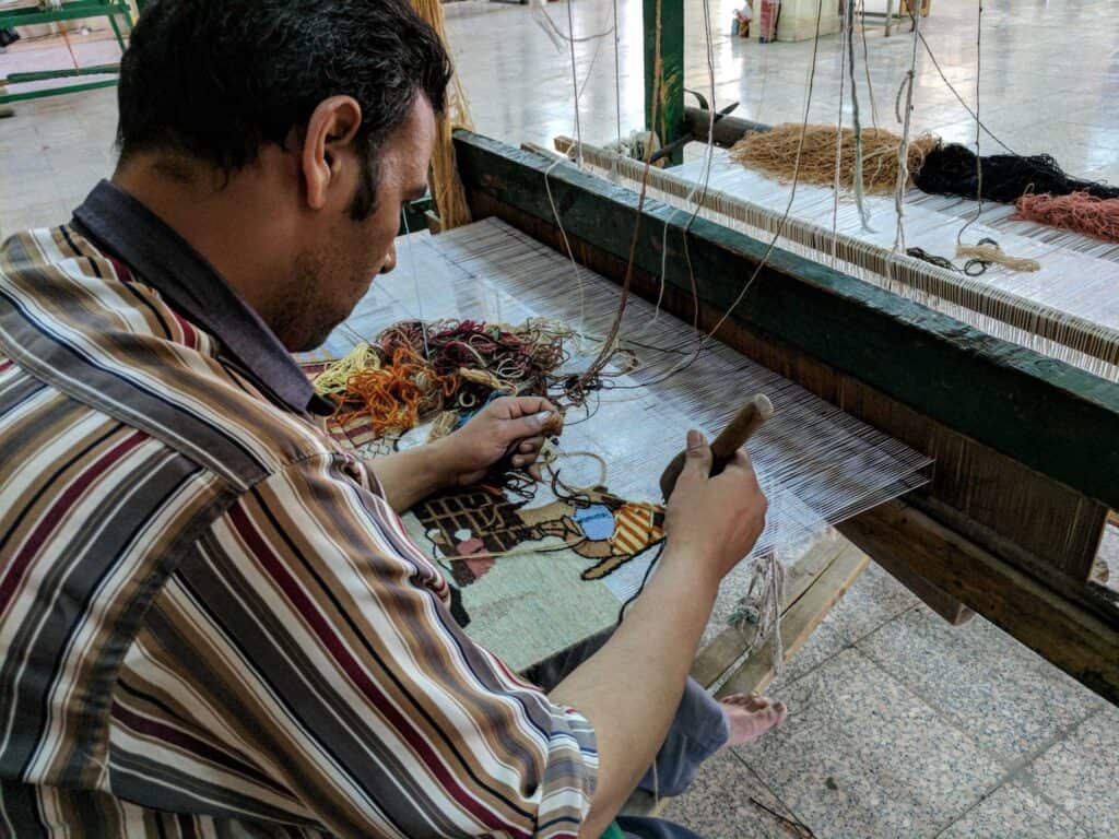 Dentro da fábrica de tapetes New Egypt, em Saqqara. Artista em trabalho.